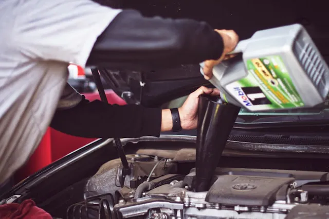 Man changing oil on car