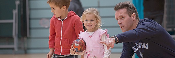 Father playing with daughter and son