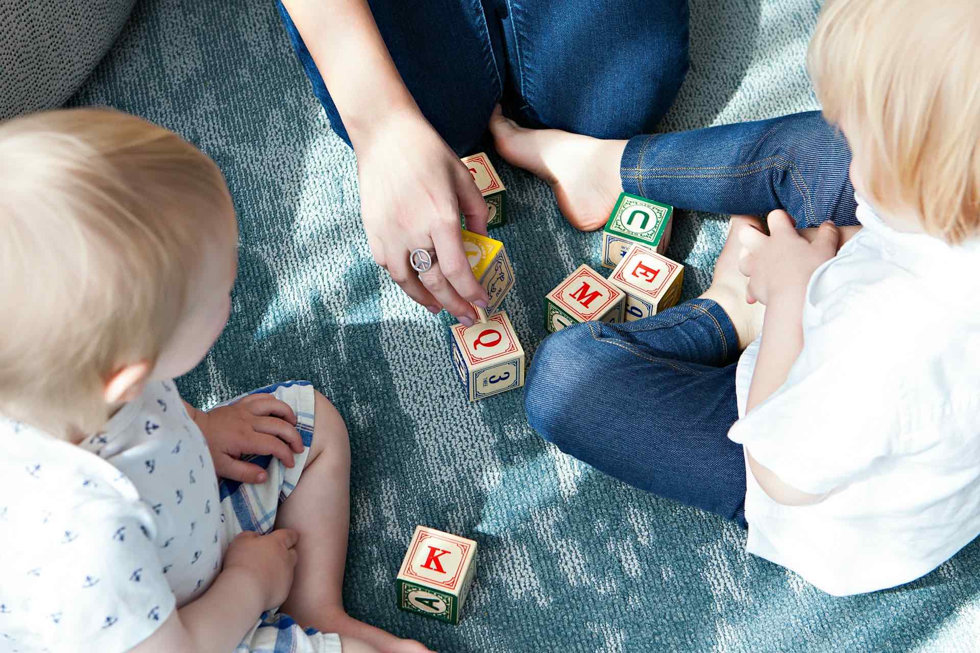 Mother teaching children with alphabet blocks