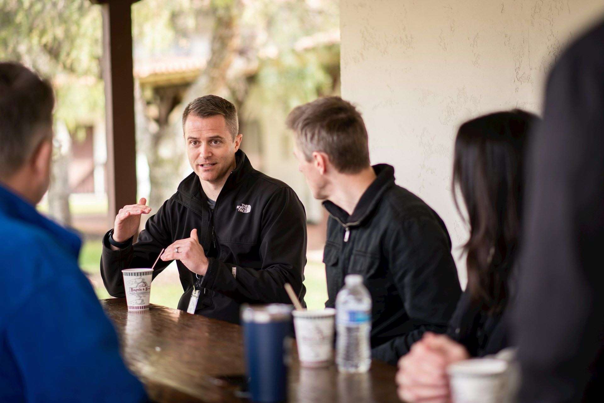 group low res Men sitting at a table talking